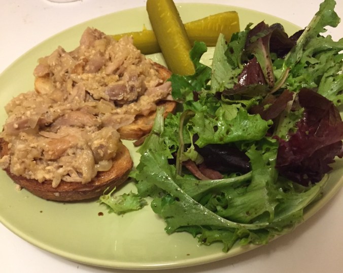 Milk-braised turkey sandwich with pickles and side salad.