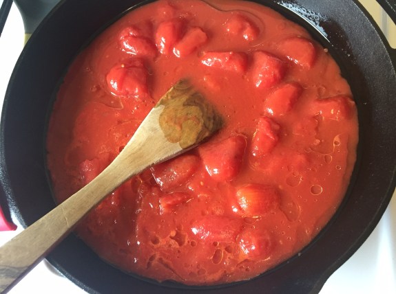 Whole peeled tomatoes in cast iron pan